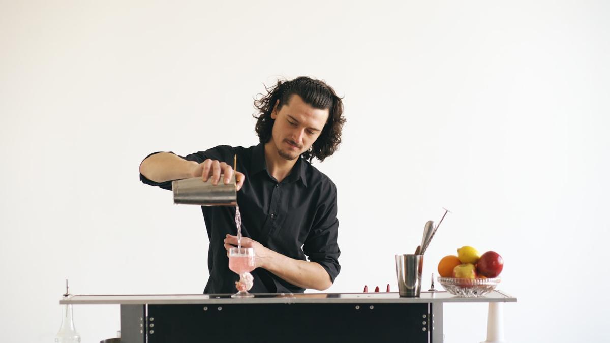 Bartender pouring a craft cocktail at an event bar