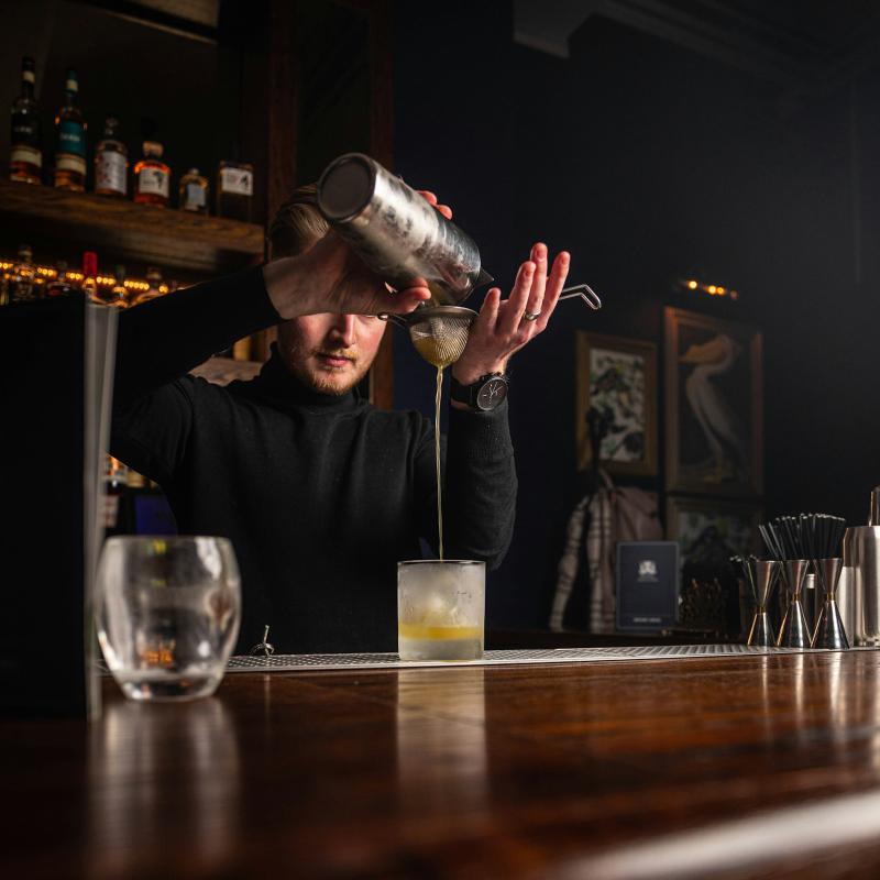Bartender pouring a drink behind the bar