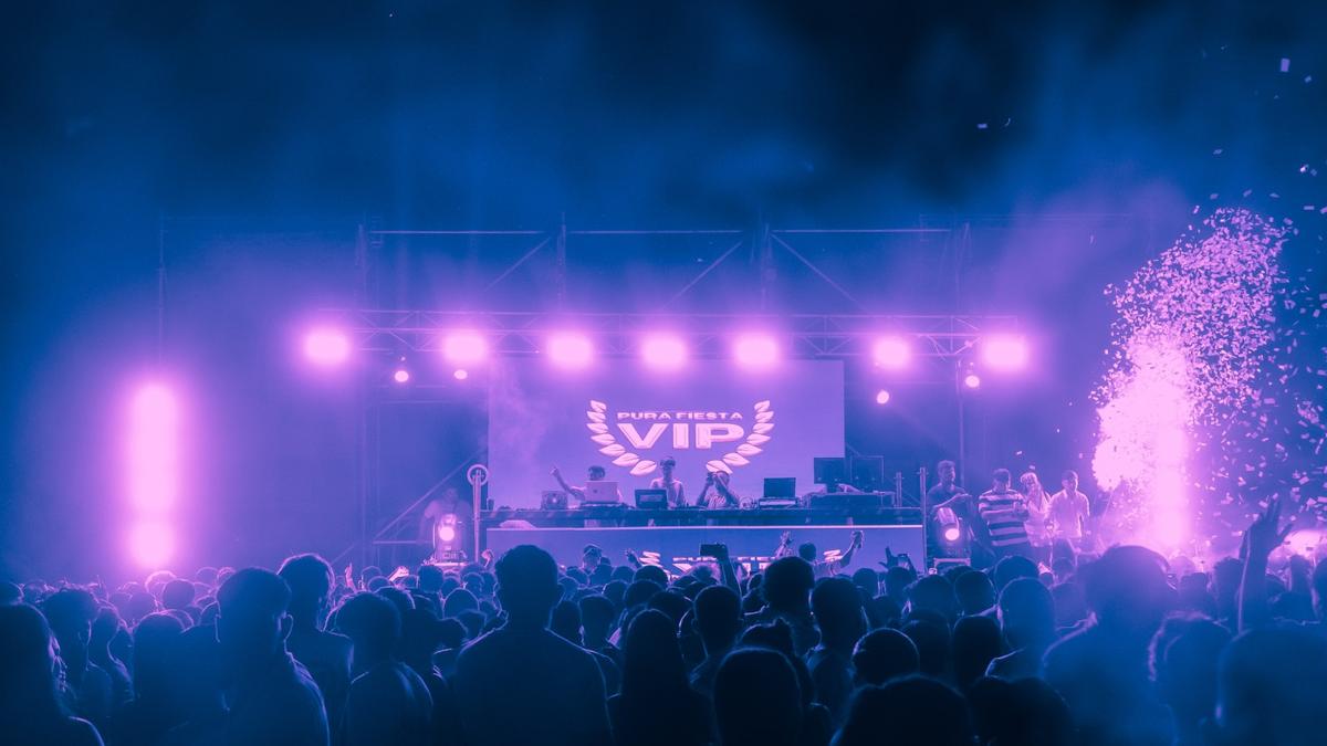 Crowd celebrating under purple event lighting