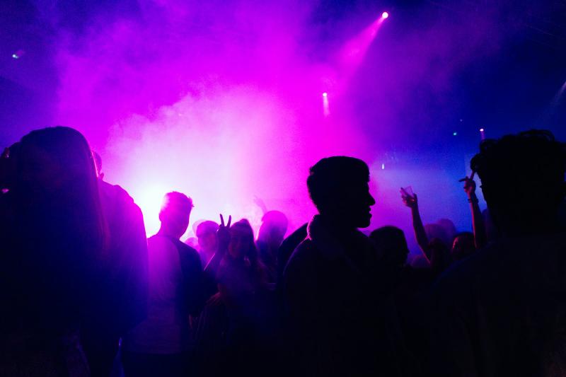 Guests under moody purple event lighting